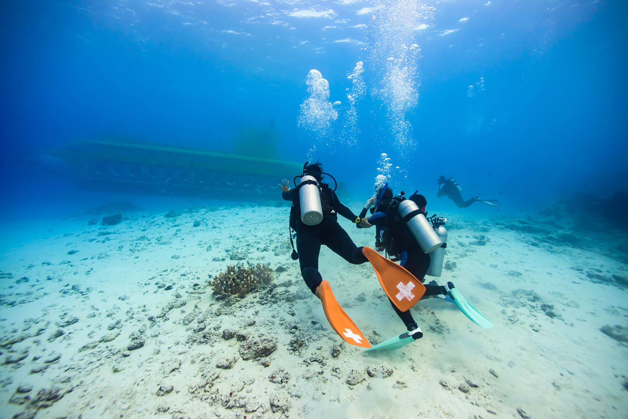 Divers exploring the Philippine Sea near the coast of Tinian, Northern Mariana Islands