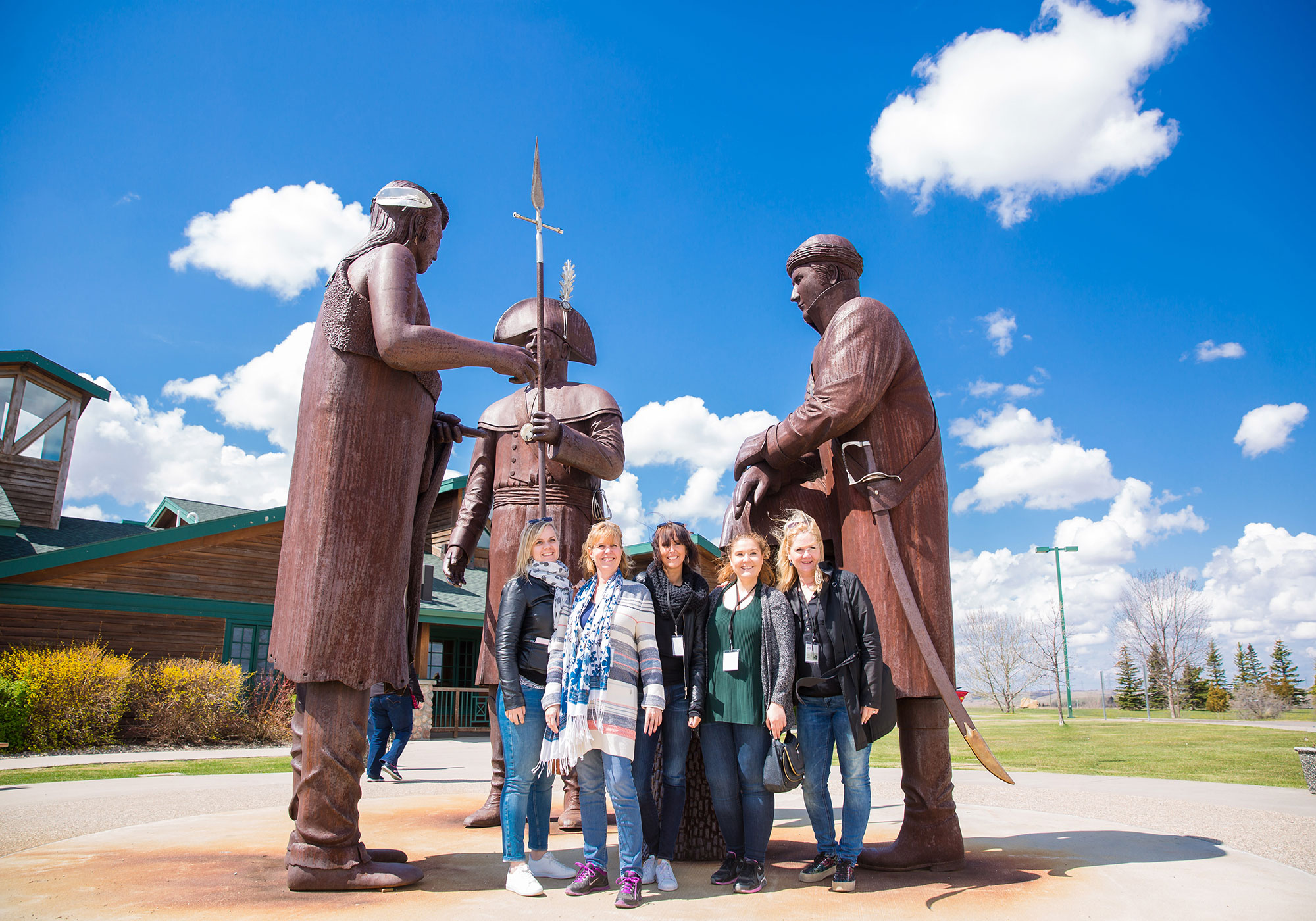 Visitors posing for a photo with statues at the Lewis and Clark Interpretive Center in North Dakota