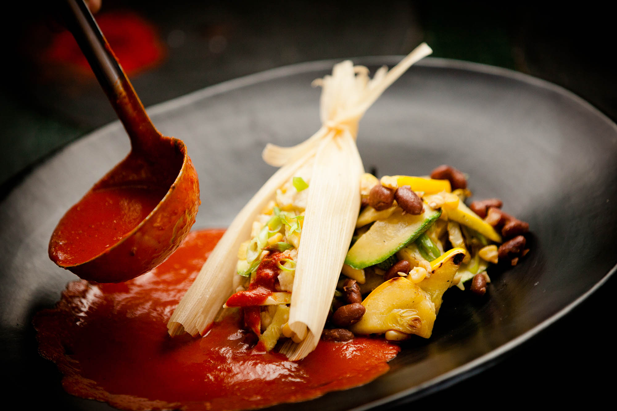 A close-up of tamales served with red chile, a classic dish in Santa Fe, New Mexico