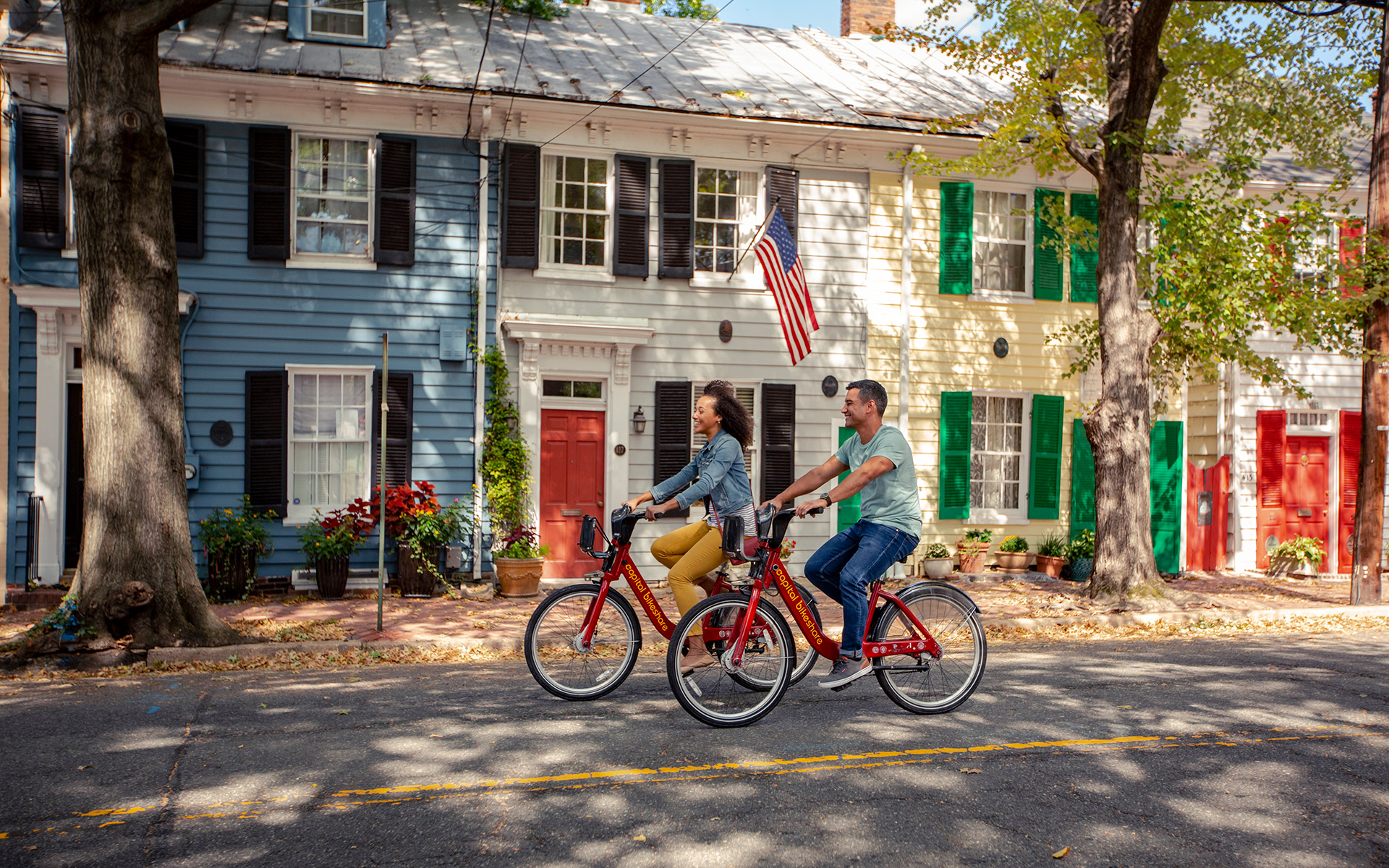 Couple biking on Queen Street in Old Town Alexandria, Virginia. Credit: Kristian Summerer

