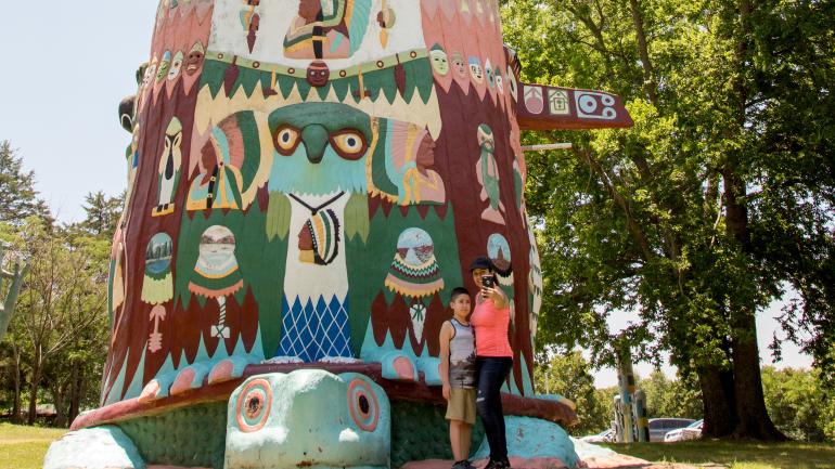 Visitors posing at Ed Galloway’s Totem Pole Park in Chelsea; Credit: Lori Duckworth/Oklahoma Tourism
