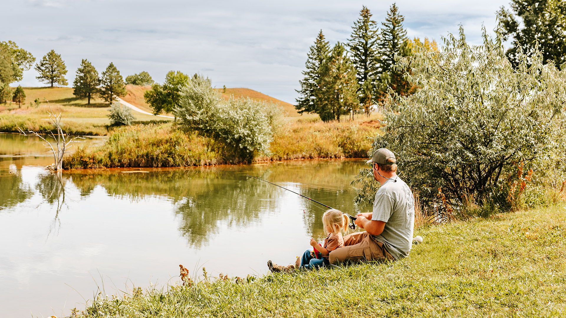 Father and daughter fishing at Sundance Pond in Devils Tower Country, Wyoming