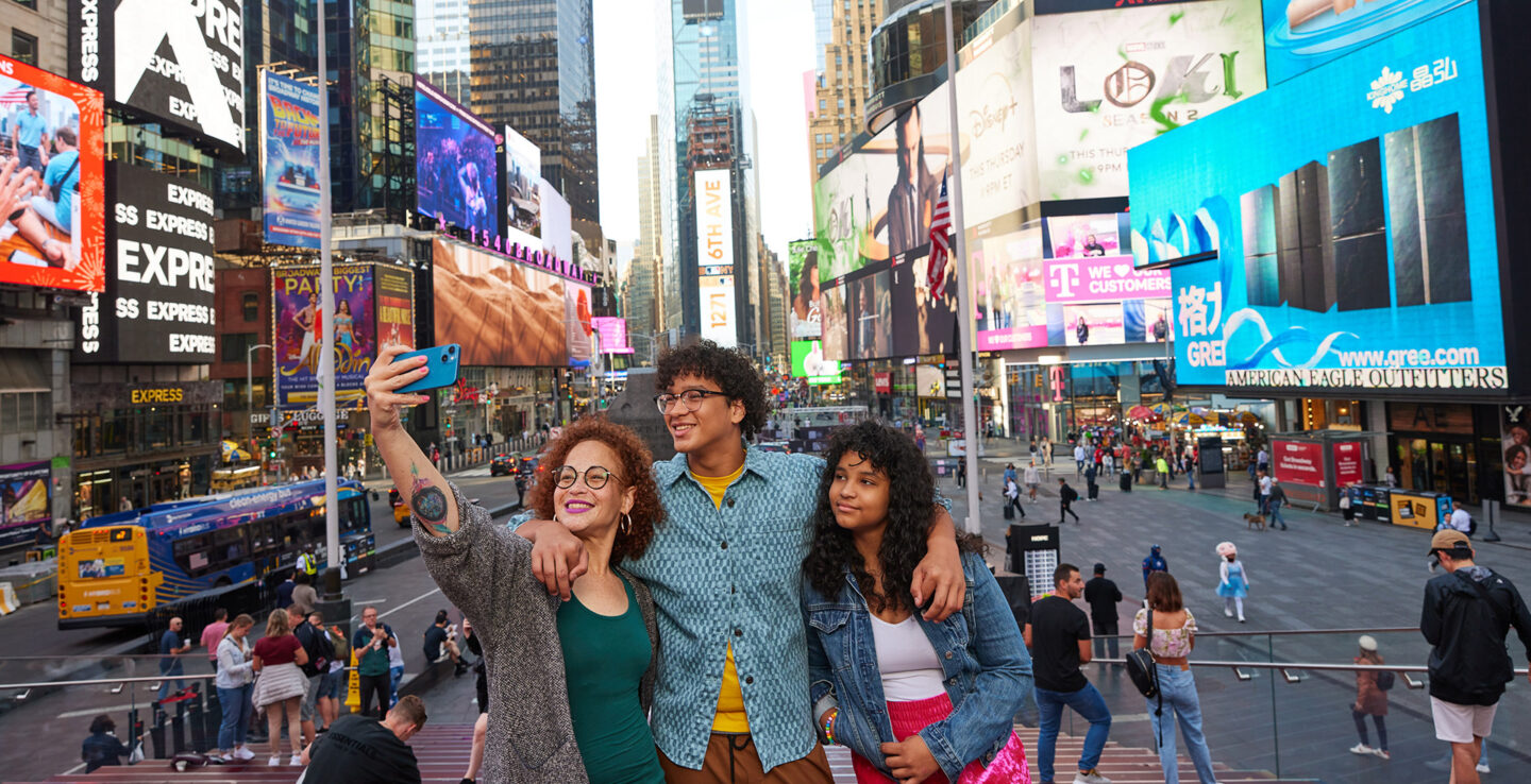 Family posing for a photo in Times Square in Manhattan, New York