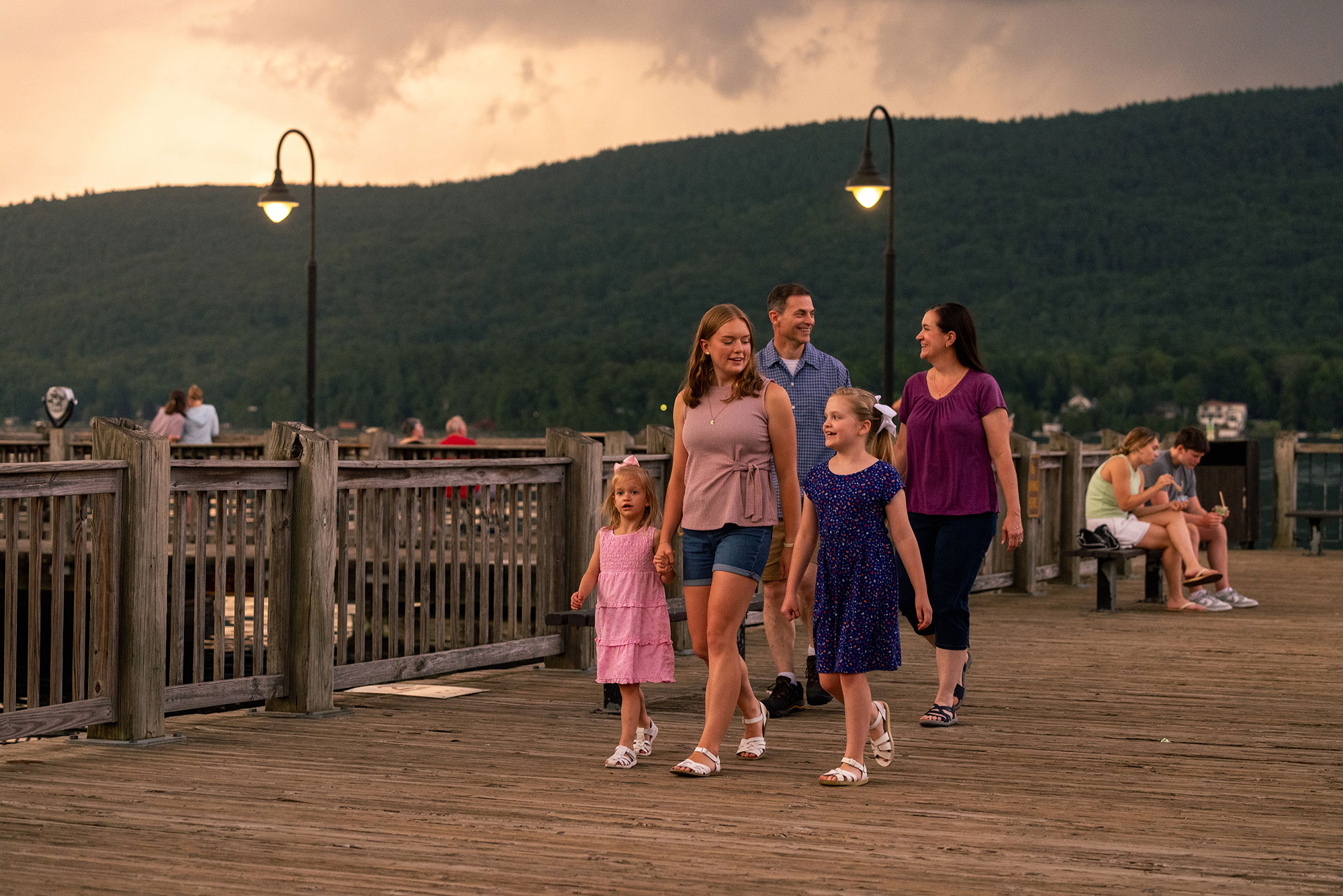 Family walking along the MacDonald Pier at Shepard Park in Lake George, New York