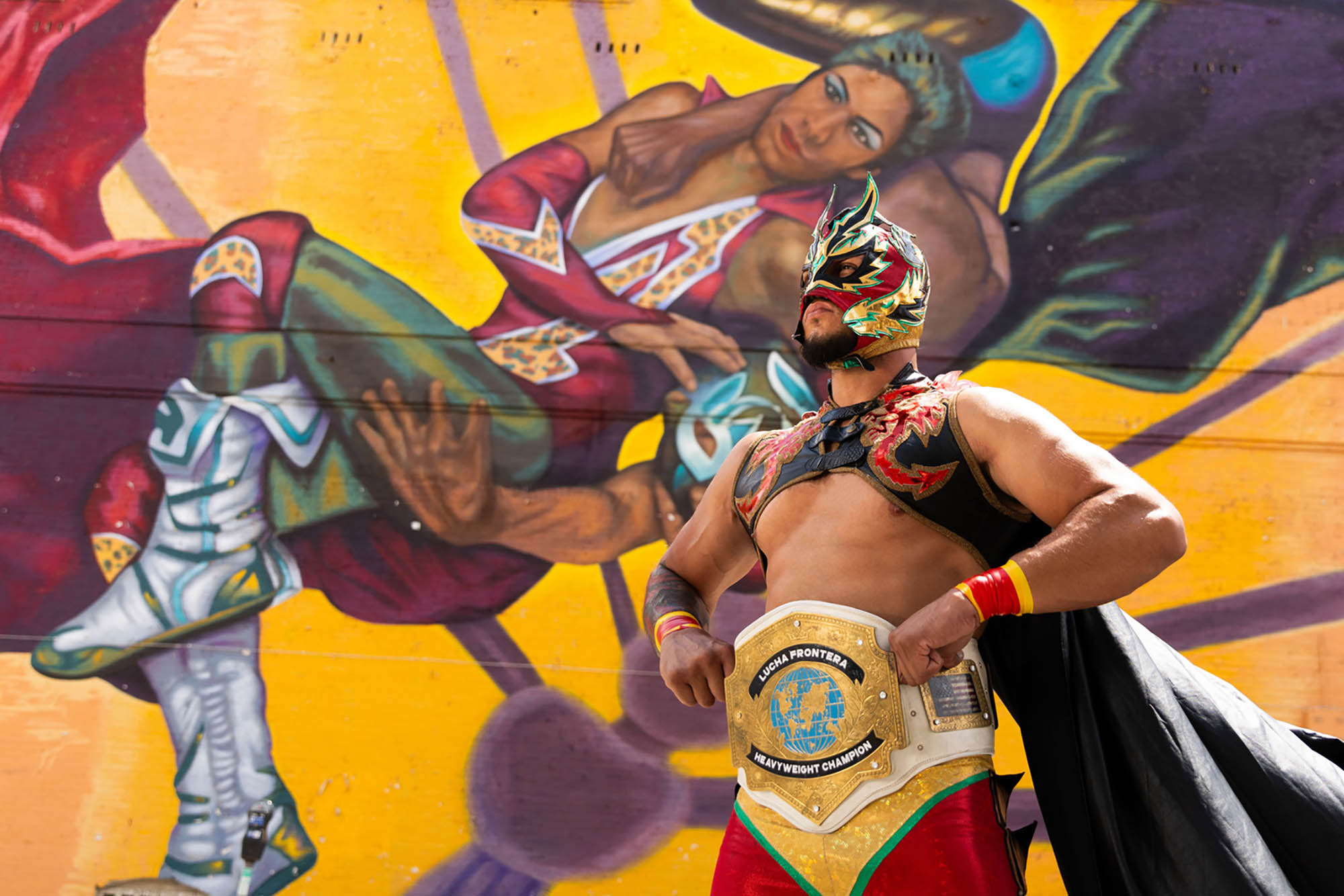 A Mexican wrestler posing with a street mural in El Paso, Texas;
Credit: Visit El Paso
